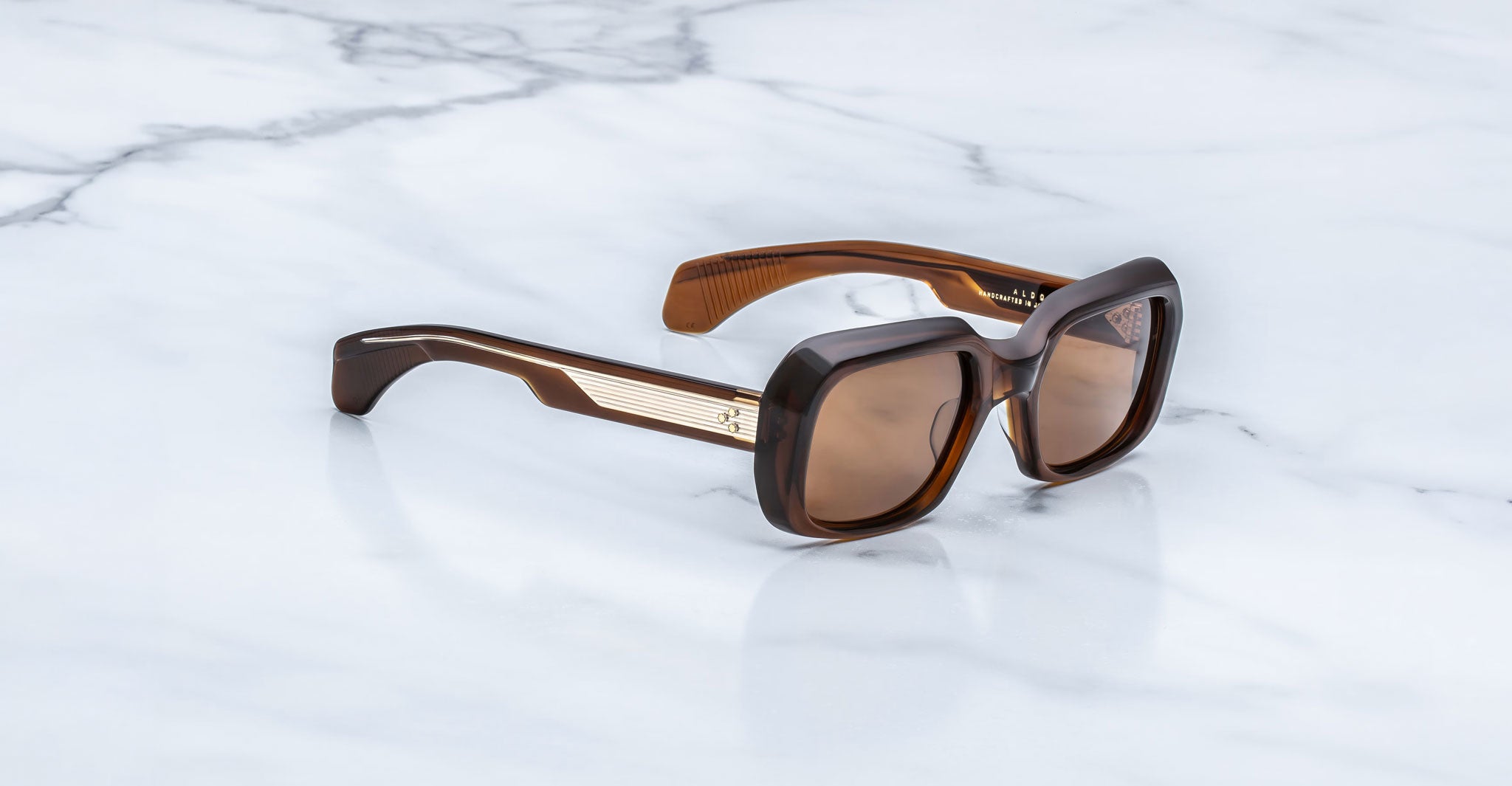 Jacques Marie Mage Aldo brown square sunglasses with UV lenses and gold accents, top view.
