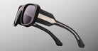 Jacques Marie Mage Alfie black rectangular sunglasses with thick frames, dark lenses, and metallic accents on the temples, front view.