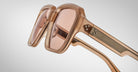 Close-up of Jacques Marie Mage Alfred oversized, square sunglasses in translucent peach with tinted lenses and textured temple arms, displayed on a plain white background.