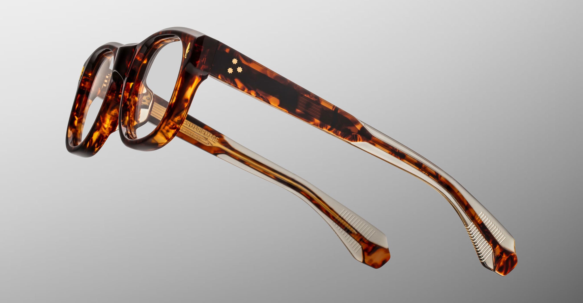 Jacques Marie Mage Amilcar tortoiseshell eyeglasses with gold accents, partially folded, viewed from above.