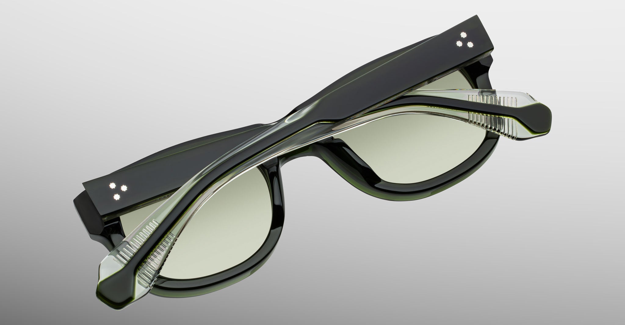 Jacques Marie Mage Amilcar sunglasses with black frames and clear lenses, shown folded from a top-down angle.