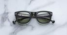 Jacques Marie Mage Amilcar aviator sunglasses with thick black frames and silver accents, shown from above.