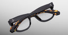 Jacques Marie Mage Amilcar thick-rimmed black tortoiseshell eyeglasses, folded, viewed from above.