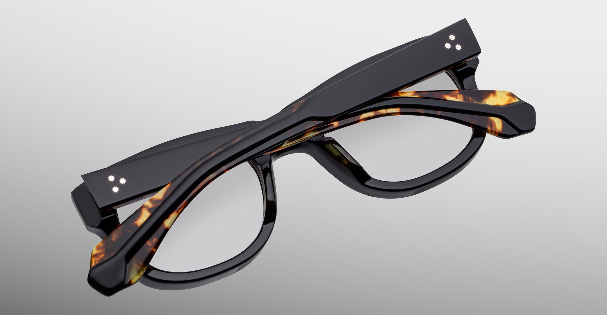 Jacques Marie Mage Amilcar thick-rimmed black tortoiseshell eyeglasses, folded, viewed from above.