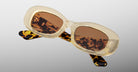 Jacques Marie Mage Ann in Dune, angled view showing translucent beige frame and warm brown tinted lenses