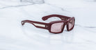 Jacques Marie Mage Apollo in Bordeaux Empire shown in angled side view, featuring a bold rectangular burgundy acetate frame, thick sculpted temples with exposed engraved metal core, triple dot rivets, signature arrowhead tips, and rose-tinted lenses.