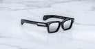 Jacques Marie Mage Ashcroft in Black Mirror acetate featuring a bold rectangular frame, signature arrowhead front pins, exposed engraved wirecore temples, sculpted temple tips, and grey tinted lenses