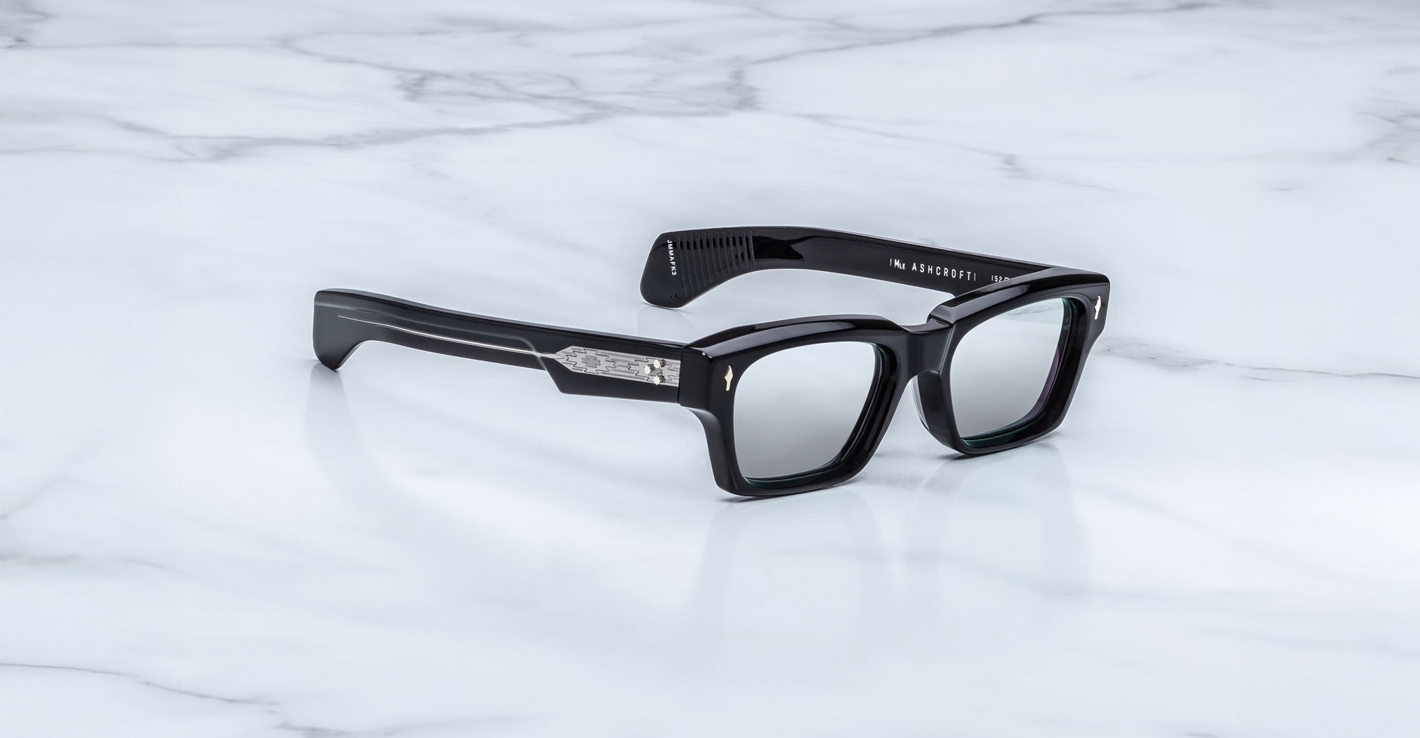 Jacques Marie Mage Ashcroft in Black Mirror acetate featuring a bold rectangular frame, signature arrowhead front pins, exposed engraved wirecore temples, sculpted temple tips, and grey tinted lenses