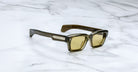 Jacques Marie Mage Ashcroft in Volvox acetate featuring a bold rectangular green frame, signature arrowhead front pins, exposed engraved wirecore temples, sculpted temple tips, and yellow tinted lenses