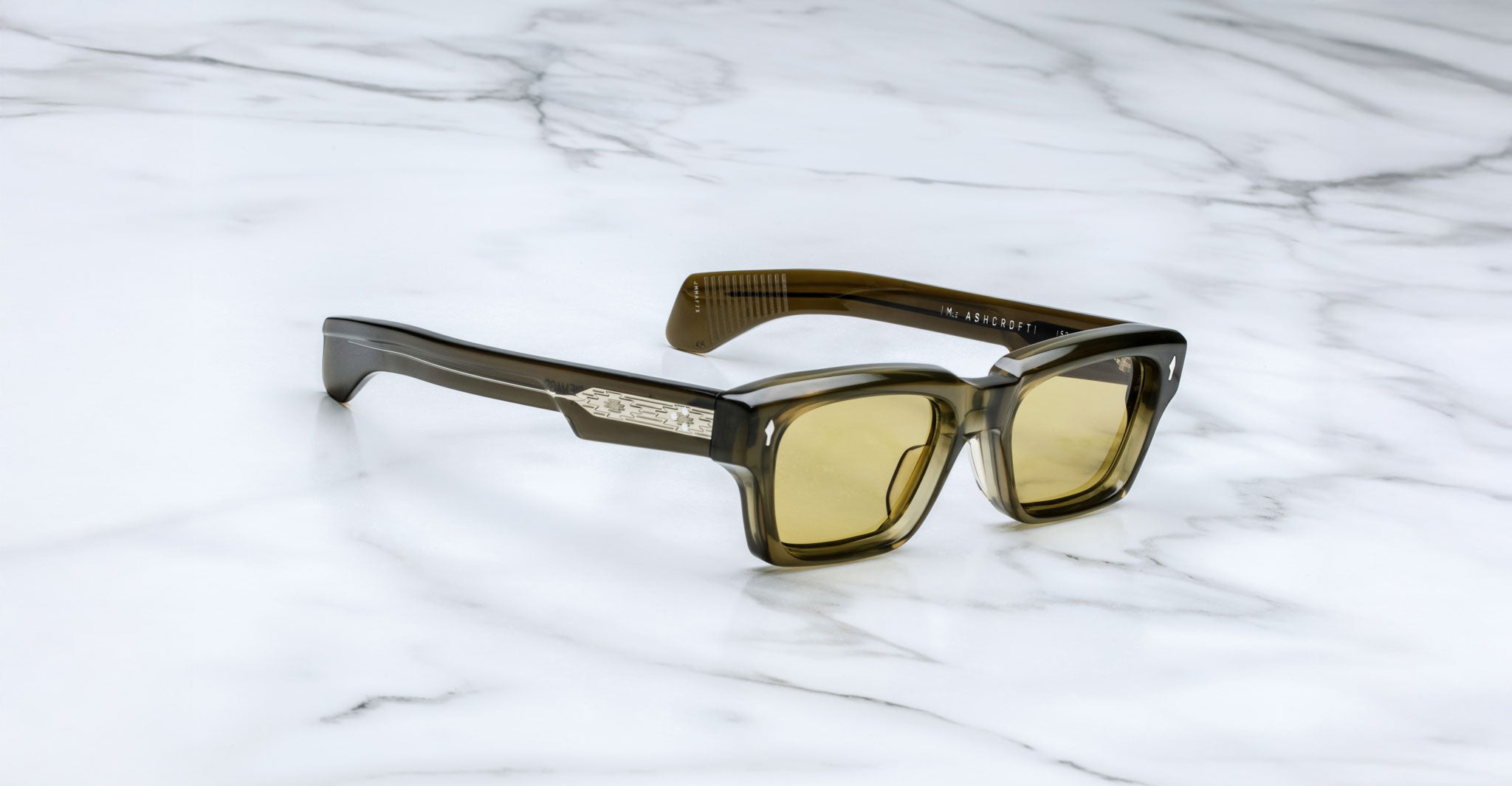 Jacques Marie Mage Ashcroft in Volvox acetate featuring a bold rectangular green frame, signature arrowhead front pins, exposed engraved wirecore temples, sculpted temple tips, and yellow tinted lenses