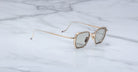 Jacques Marie Mage Atkins gold square sunglasses with gray UV-protective lenses, front view.
