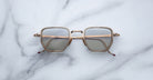 Jacques Marie Mage Atkins gold square eyeglasses with clear blue light lenses, top-down view.