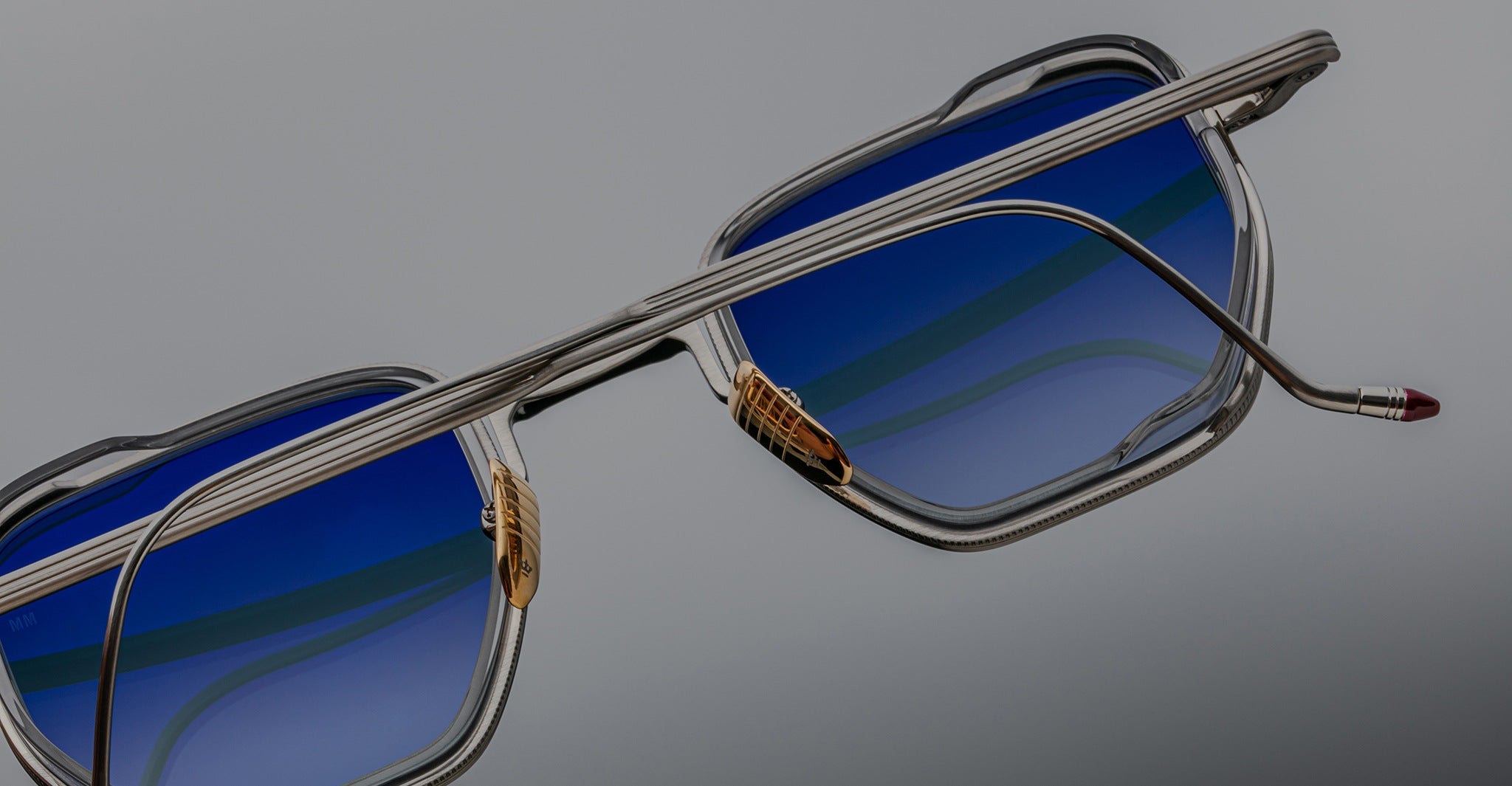 Close-up of Jacques Marie Mage Atkins eyeglasses, rectangular shape, blue-tinted lenses, silver frames, front view.