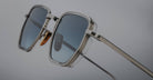 Close-up of Jacques Marie Mage Atkins sunglasses, silver frame with blue lenses, viewed from the front.