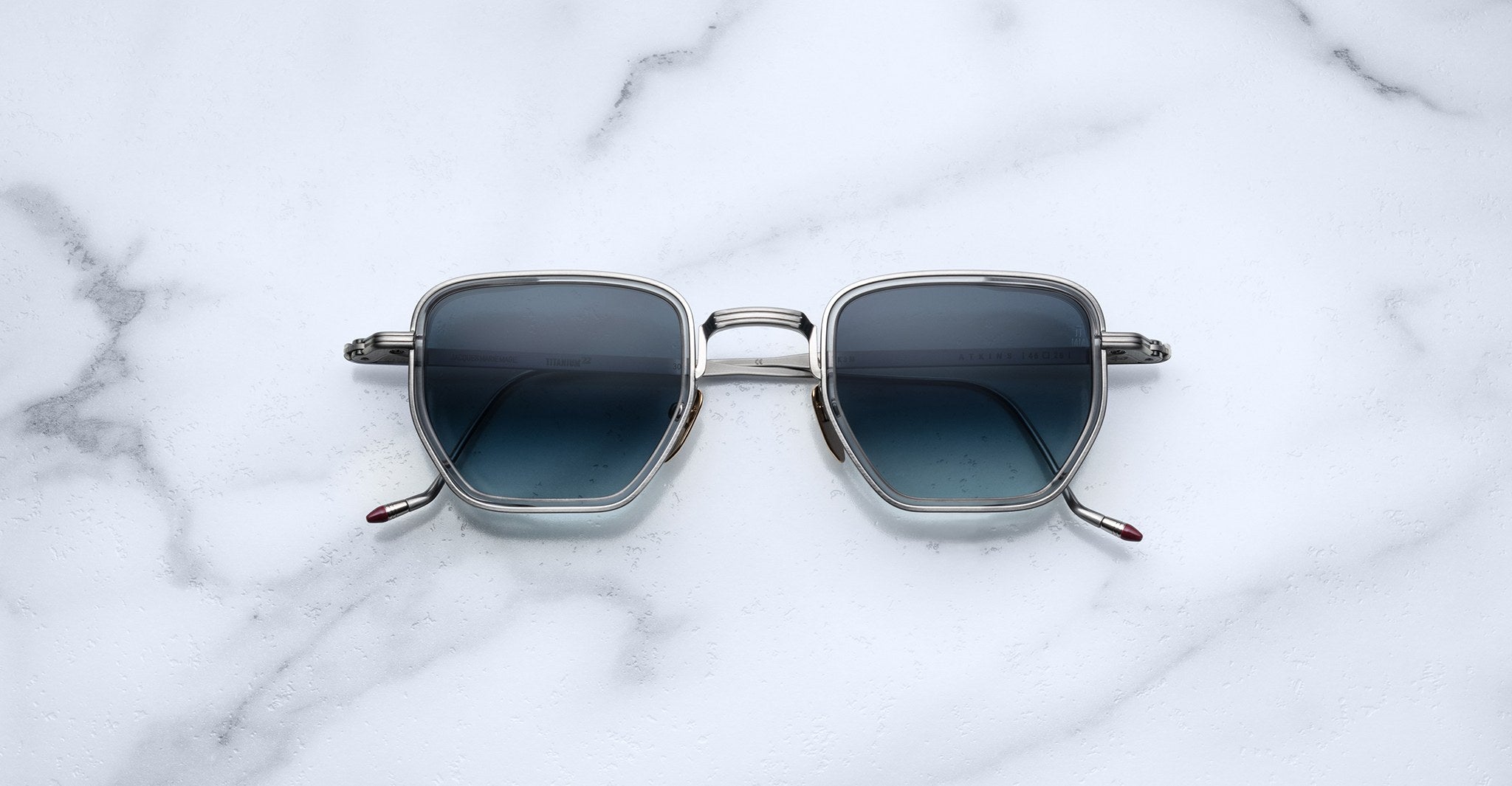 Jacques Marie Mage Atkins square sunglasses with dark lenses and silver rims, top view.