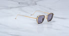 Jacques Marie Mage Atkins square sunglasses with gold frames and dark lenses, top view.