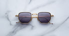 Jacques Marie Mage Atkins sunglasses feature gold frames and dark lenses, shown from above for a clear view of the product design.