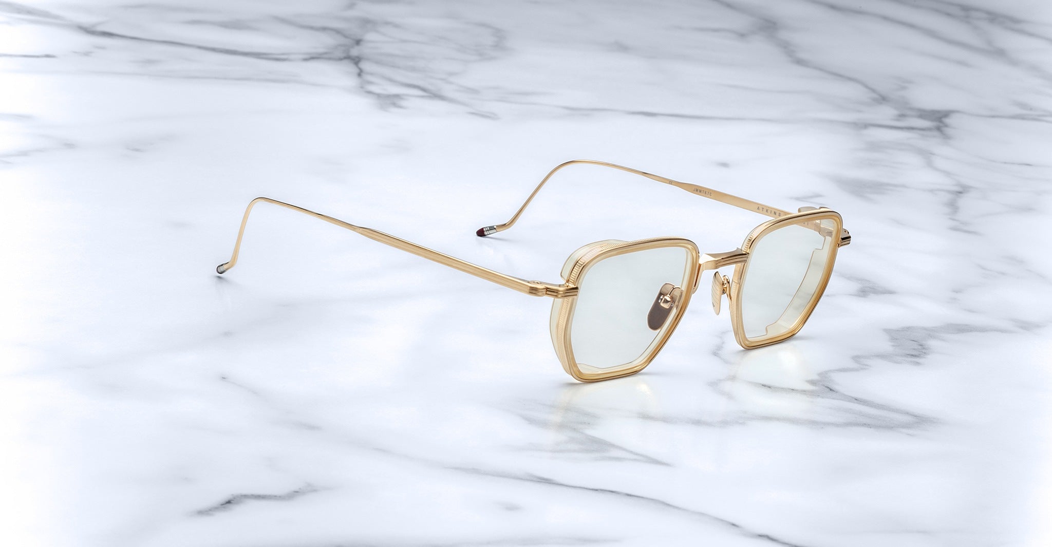 Jacques Marie Mage Atkins gold-framed sunglasses with light tinted lenses, shown from above.