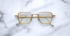 Jacques Marie Mage Atkins square eyeglasses, gold rims, clear lenses, front view.