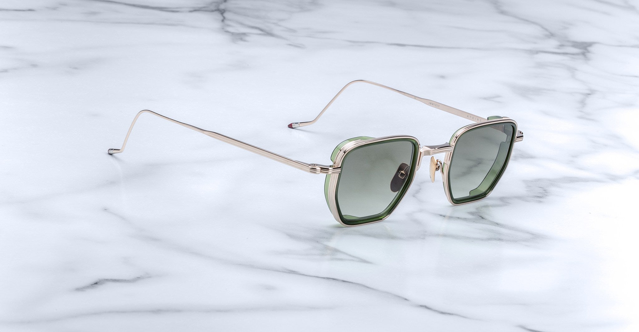 Jacques Marie Mage Atkins sunglasses, heart-shaped green lenses with gold frames, top-down view.