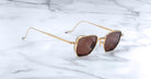 Jacques Marie Mage Atkins aviator sunglasses with gold frames and brown lenses, top view.