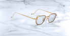 Jacques Marie Mage Atkins square sunglasses with gold rims and light gray lenses, front angle.