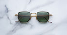 Jacques Marie Mage Atkins sunglasses featuring gold frames and green lenses, shown from above.