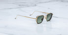 Jacques Marie Mage Atkins square sunglasses with gold frames and green lenses, front view.