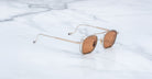 Jacques Marie Mage Baudelaire 2 sunglasses with gold frames and brown lenses, front view.