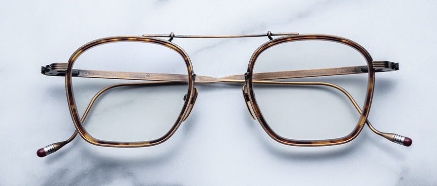 Jacques Marie Mage Baudelaire square tortoiseshell eyeglasses with gold bridge and arms, top view.