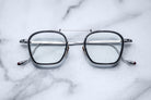 Jacques Marie Mage Baudelaire 2 square metal eyeglasses, prescription type, shown from above on a flat surface.