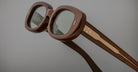 Close-up of Jacques Marie Mage Besset sunglasses, brown oval frames, tinted lenses, gold detailing, front angle.