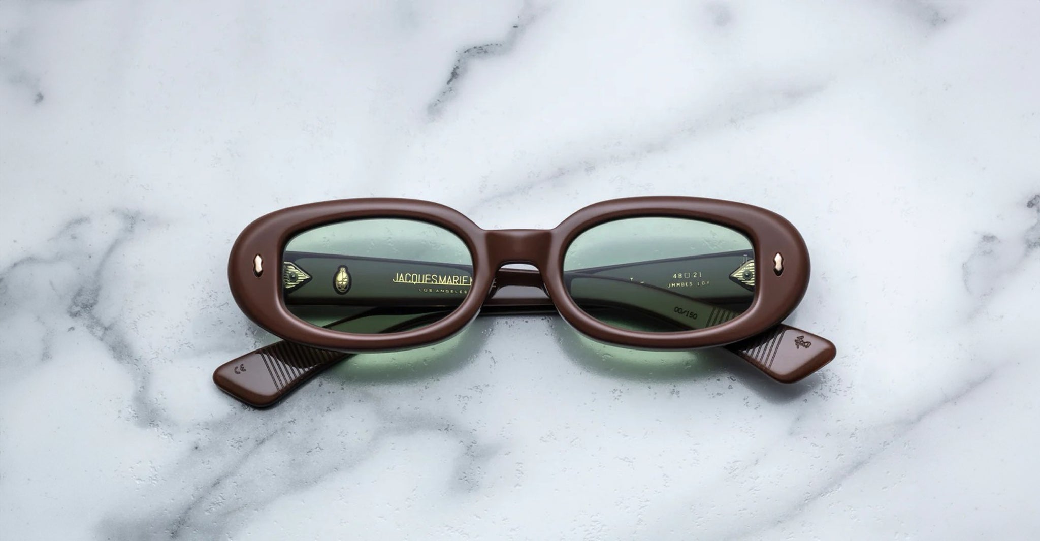 Jacques Marie Mage Besset brown oval sunglasses with green UV-protective lenses, top view.