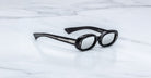 Jacques Marie Mage Besset black oval sunglasses with thick frames and silver accents, top view.