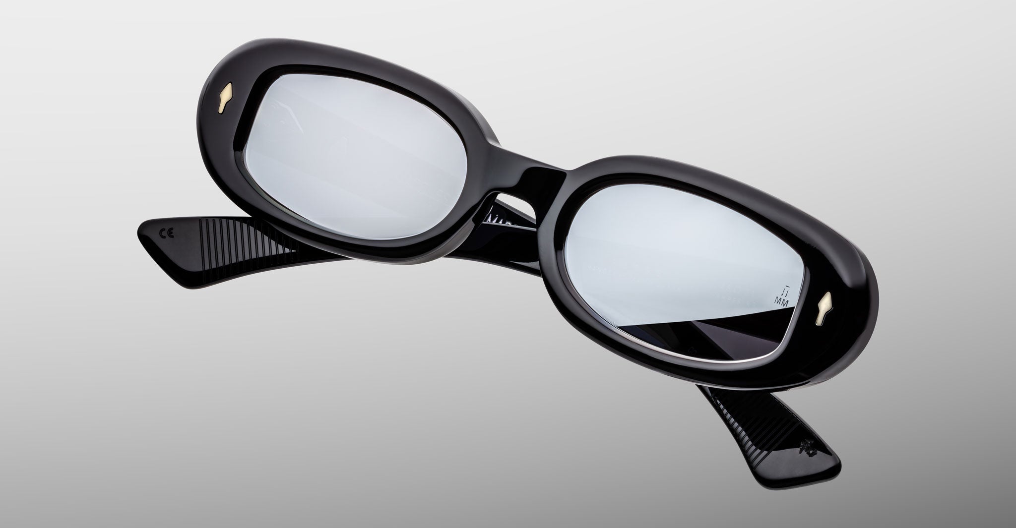 Jacques Marie Mage Besset black oval sunglasses with thick frames and reflective lenses, front view.