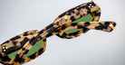 Close-up of Jacques Marie Mage Besset sunglasses, featuring tortoiseshell frames, green lenses, and bold temples.