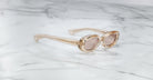 Jacques Marie Mage Besset sunglasses with clear frames and brown lenses, top view.