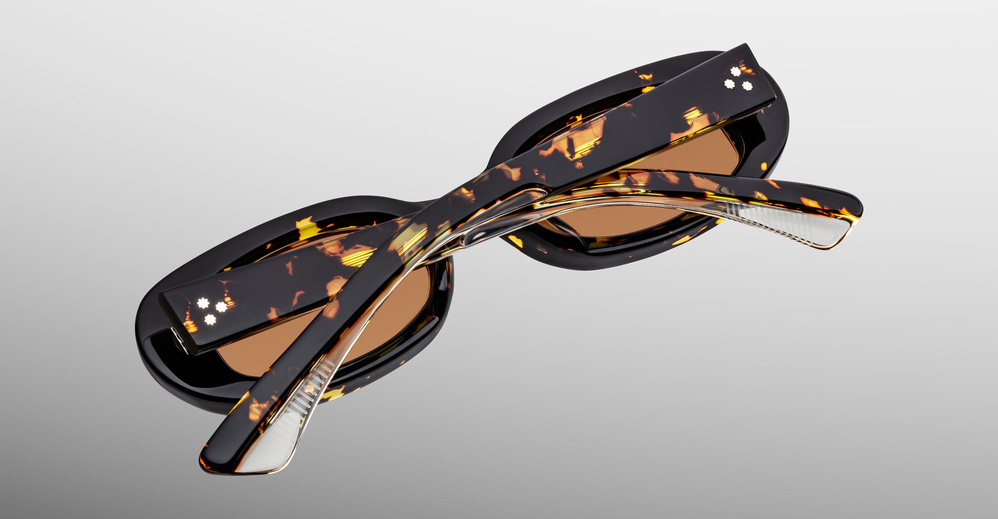 Jacques Marie Mage Besset sunglasses in brown and yellow tortoise shell pattern with orange lenses close-up back view with folded temples