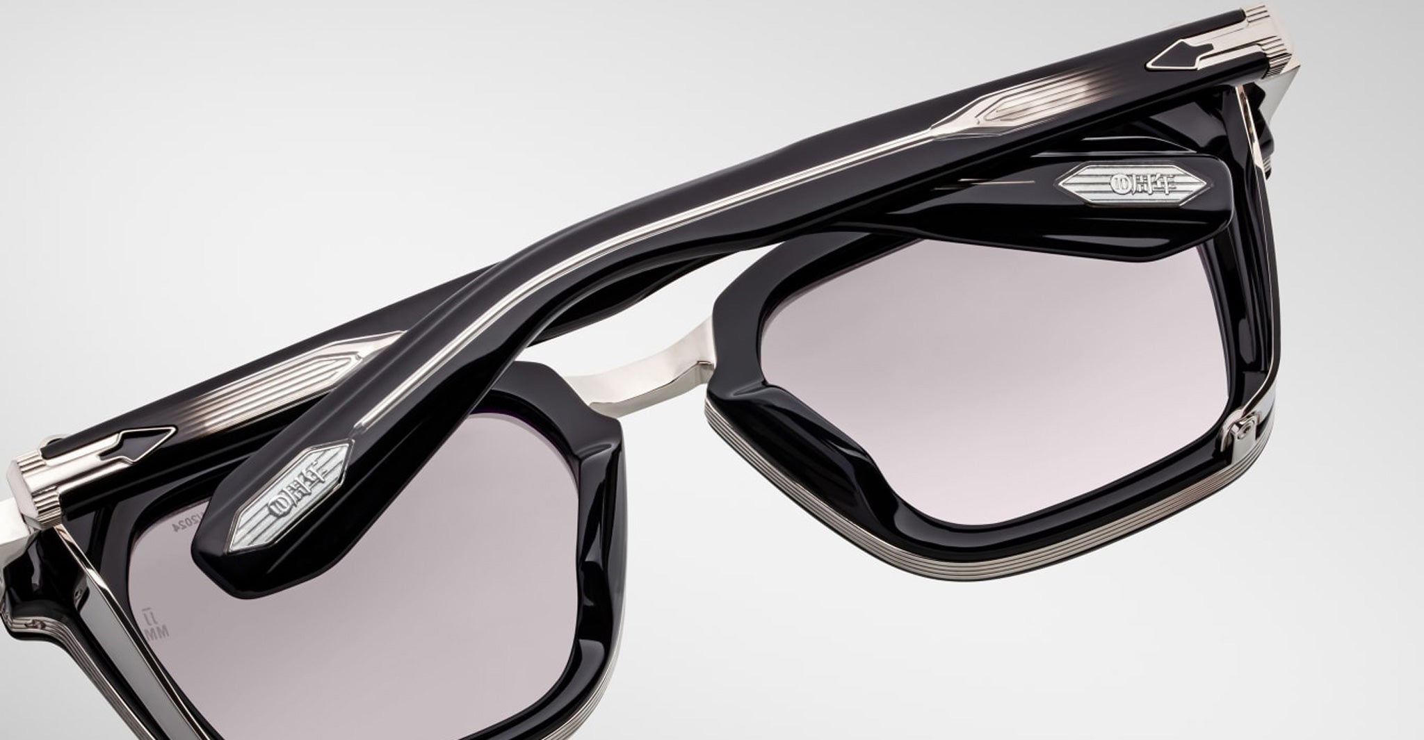 Close-up of Jacques Marie Mage Borodino rectangular sunglasses in black and silver with tinted lenses and prominent metal accents.