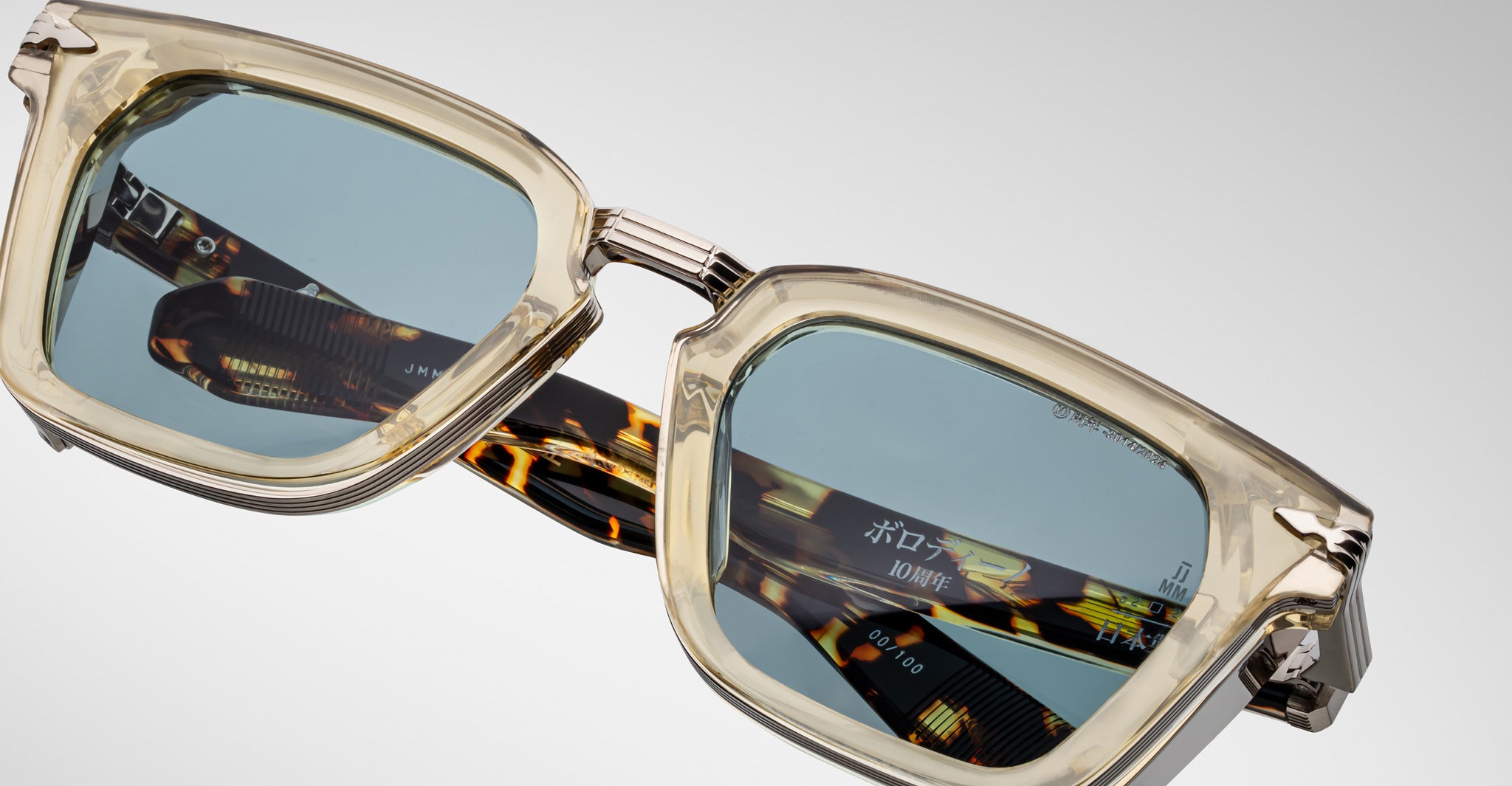 Close-up of Jacques Marie Mage Borodino sunglasses showing translucent beige rims and tortoiseshell-patterned arms.
