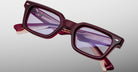 A pair of Jacques Marie Mage Casablanca rectangular eyeglasses with thick burgundy frames and slightly tinted purple lenses, displayed against a neutral background.