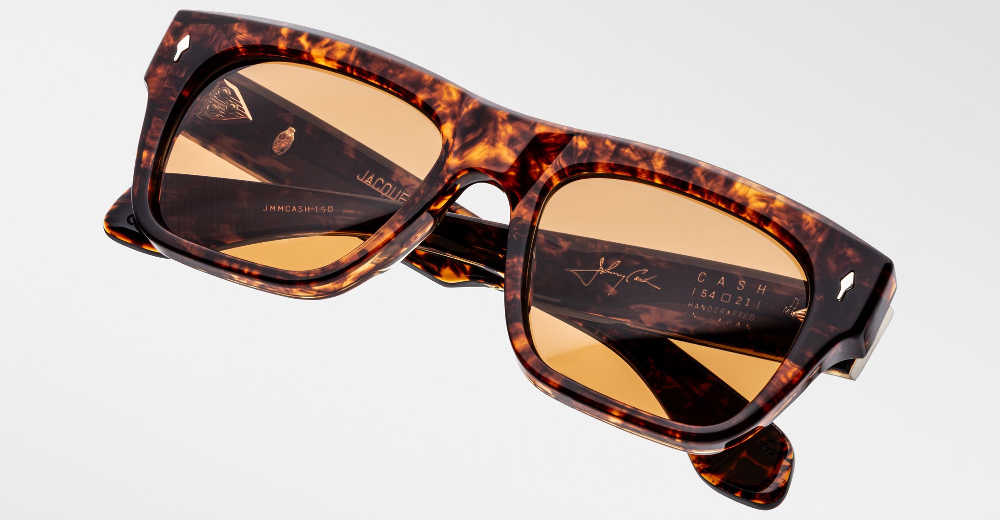 A pair of Jacques Marie Mage Cash rectangular tortoiseshell sunglasses with brown-tinted lenses and signature branding on the inner arms, shown against a plain white background.