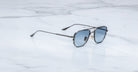 Jacques Marie Mage Cendrars aviator sunglasses with blue lenses, front view, displayed on a flat surface.