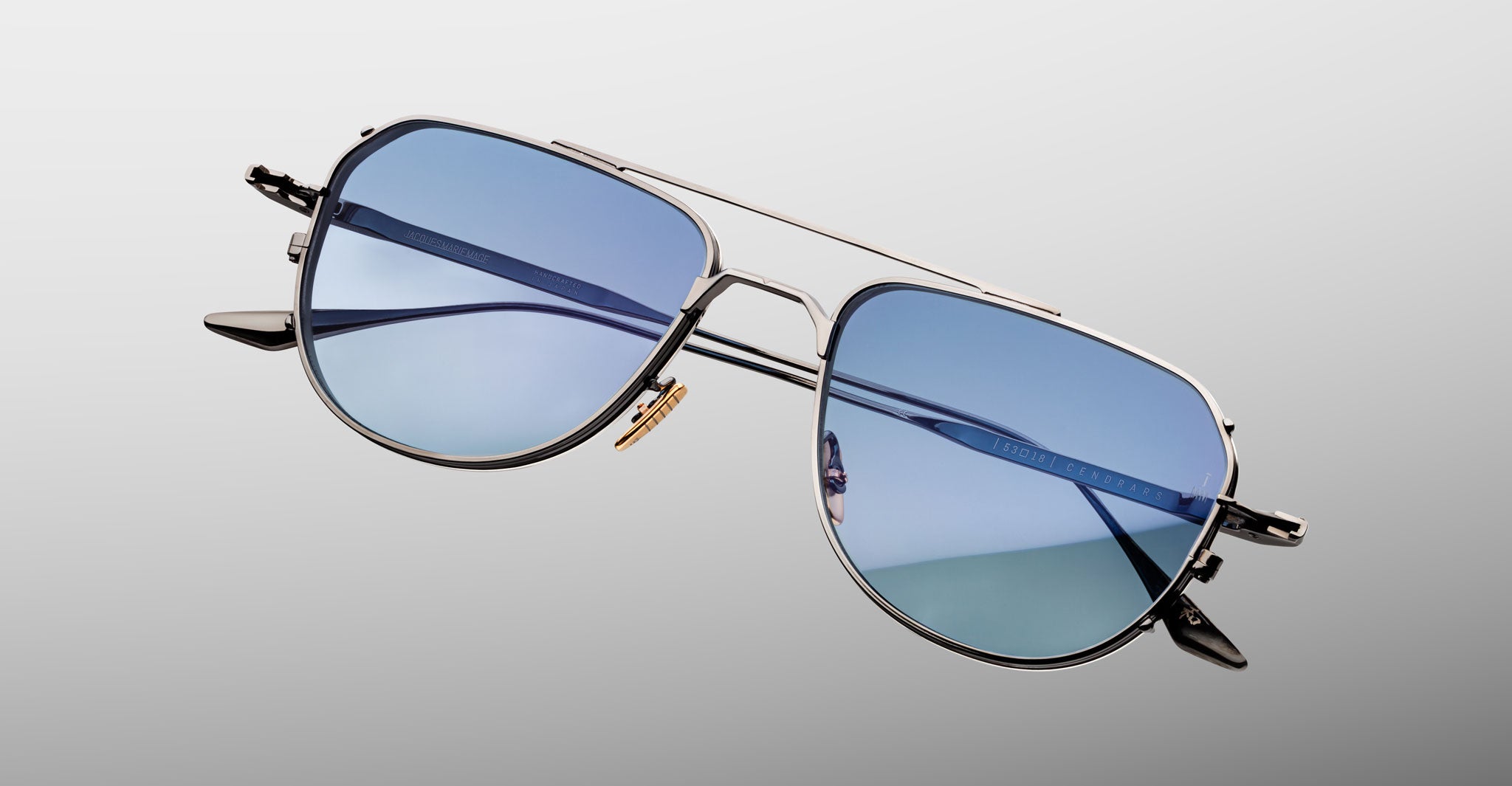 Jacques Marie Mage Cendrars aviator sunglasses with silver frames and blue lenses, shown from a front angle.