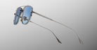 Jacques Marie Mage Cendrars silver aviator sunglasses with blue-tinted lenses, viewed from a side angle.