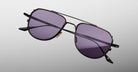 Jacques Marie Mage Cendrars sunglasses, black metal aviator frames with purple-tinted UV lenses, front view.