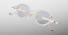 Jacques Marie Mage The Clark eyeglasses with clear frames and gold metal arms, shown from the front.