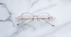 Jacques Marie Mage The Clark round eyeglasses with gold arms, shown from above, featuring minimalist design.