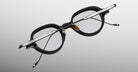 Jacques Marie Mage The Clark eyeglasses with black rims, gold nose pads, and silver temples shown from the front angle.