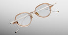 Jacques Marie Mage The Clark eyeglasses, translucent beige frames with metal arms, rear view.